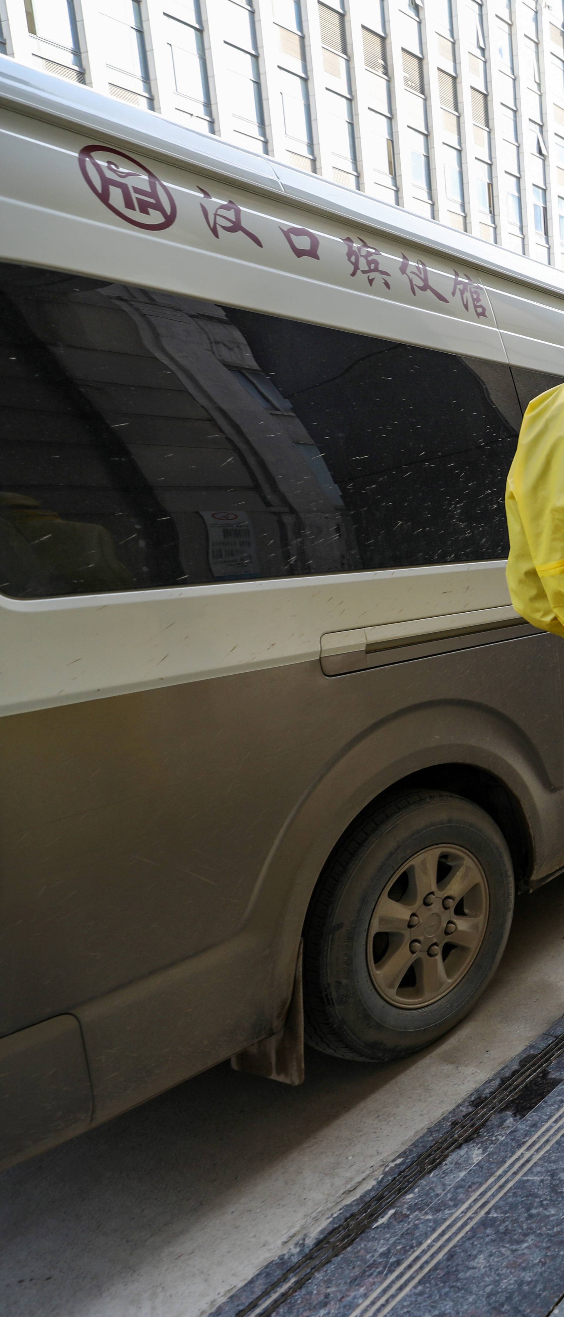 FILE PHOTO: Funeral parlour staff members in protective suits help a colleague with disinfection after they transferred a body at a hospital, following the outbreak of a new coronavirus in Wuhan