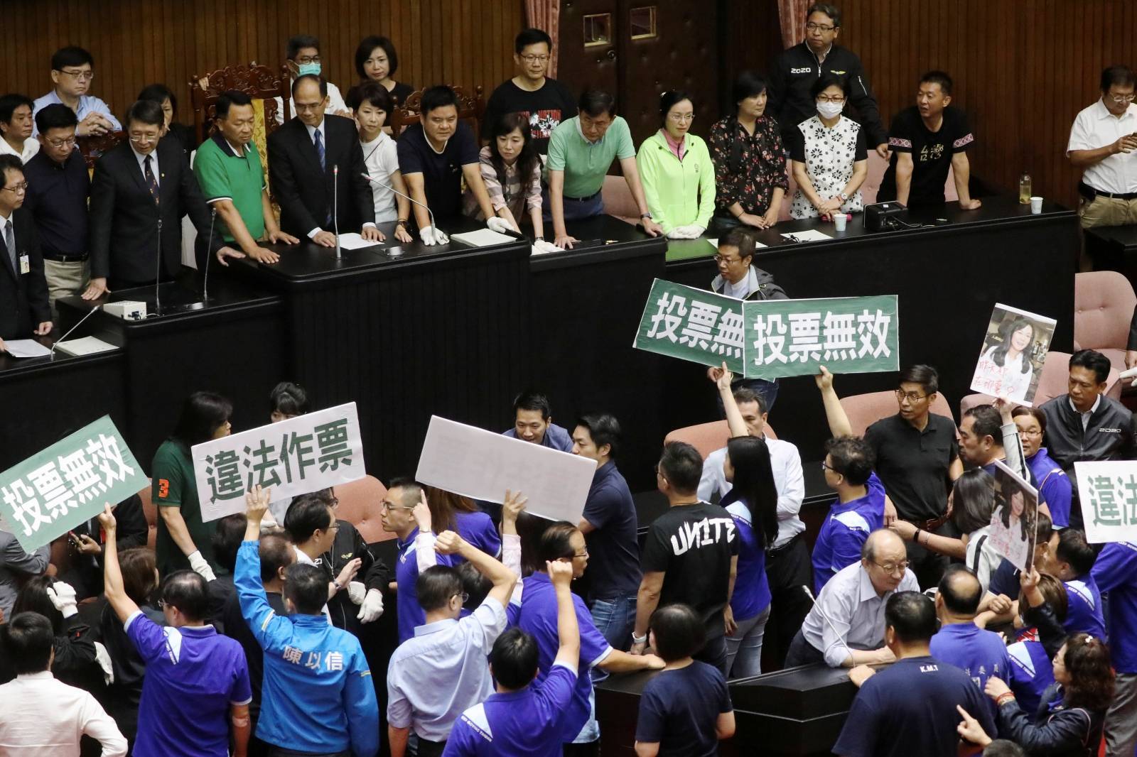 Lawmakers from Taiwan's ruling Democratic Progressive Party (DPP) argue with lawmakers from the main opposition Kuomintang (KMT) party, inside the parliament in Taipei
