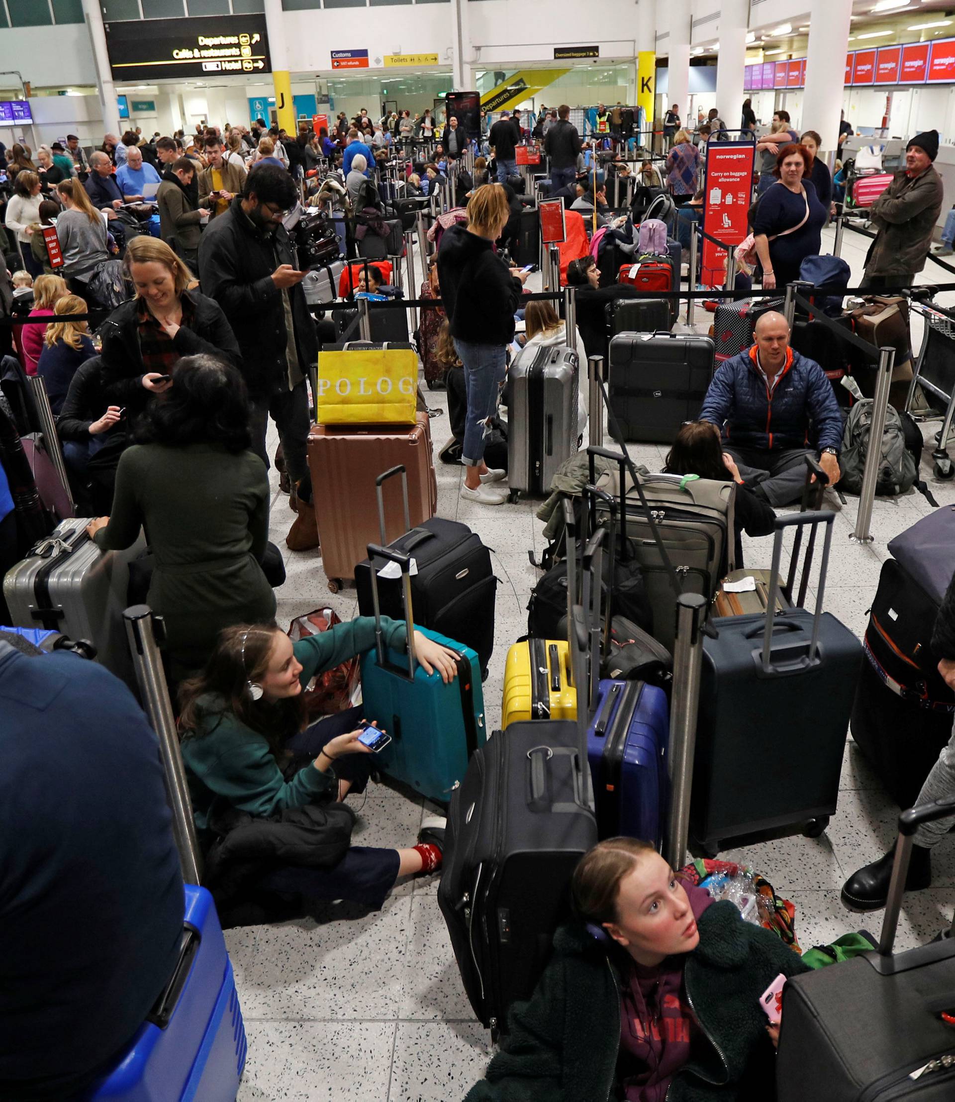 Passengers wait around in the South Terminal building at Gatwick Airport after drones flying illegally over the airfield forced the closure of the airport, in Gatwick