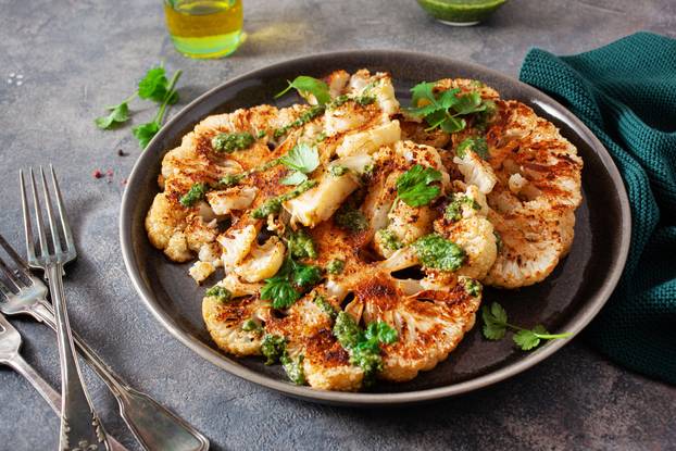 cauliflower steaks with herb sauce and spice. plant based meat s