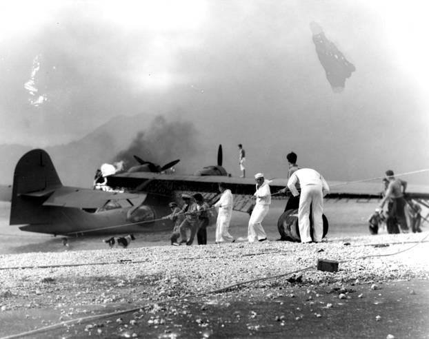 Archive photo of Sailors attempting to save a burning PBY amphibious aircraft at during the Japanese raid on Naval Air Station Kaneohe Bay