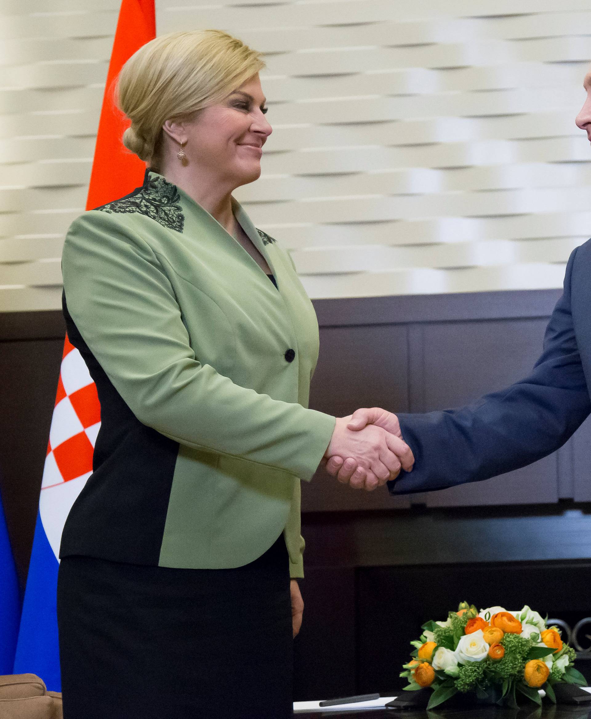Putin shakes hands with Croatian President Grabar-Kitarovic during their meeting in Sochi