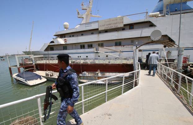 An Iraqi policeman walks past the yacht called "Basrah Breeze", once owned by former Iraqi president Saddam Hussein, who was toppled in a U.S.-led invasion in 2003, in the southern port of Basra