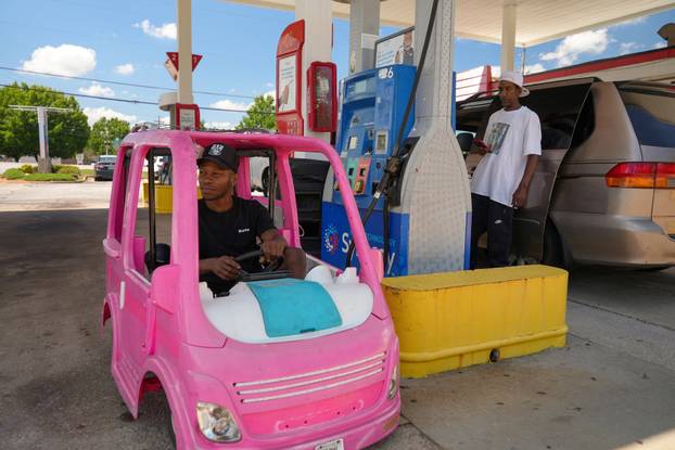 Mali Hightower poses with a pink Power Wheels Barbie Dream Camper outside a gas station in Ellenwood