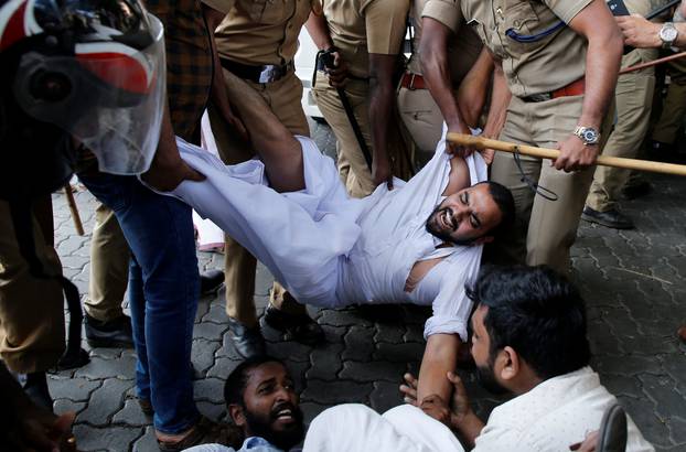 Police remove members of Kerala Students Union as they take part in a protest after two women entered the Sabarimala temple in Kochi