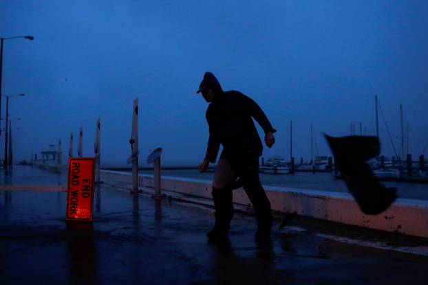 Debris flies past as Stewart Adams, of San Marcos, Texas, balances himself from a gust of wind from Hurricane Harvey along the boardwalk in Corpus Christi,