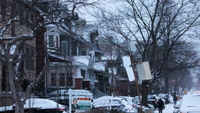 House sold sign is seen after an overnight snow storm, in Toronto