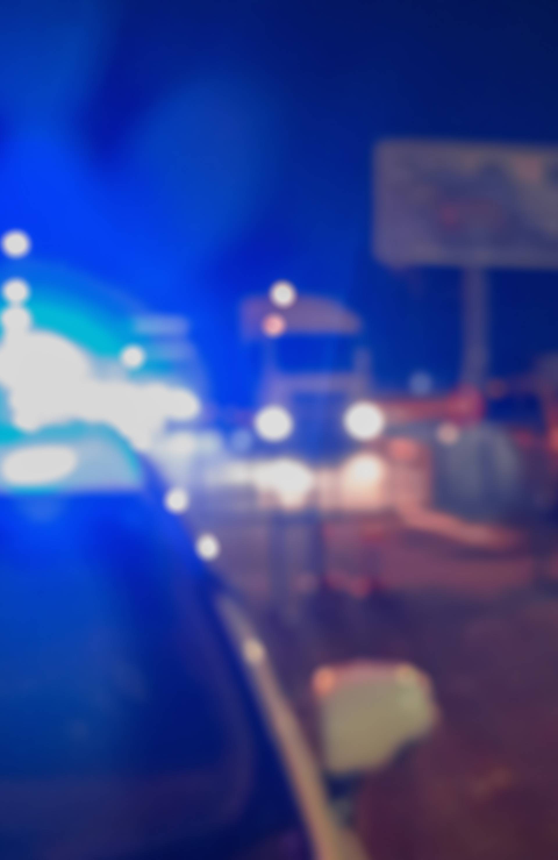 Unrecognizable blurry police car lights and police force officer on night road background, crime scene, night patrolling the city. Abstract  defocused image.