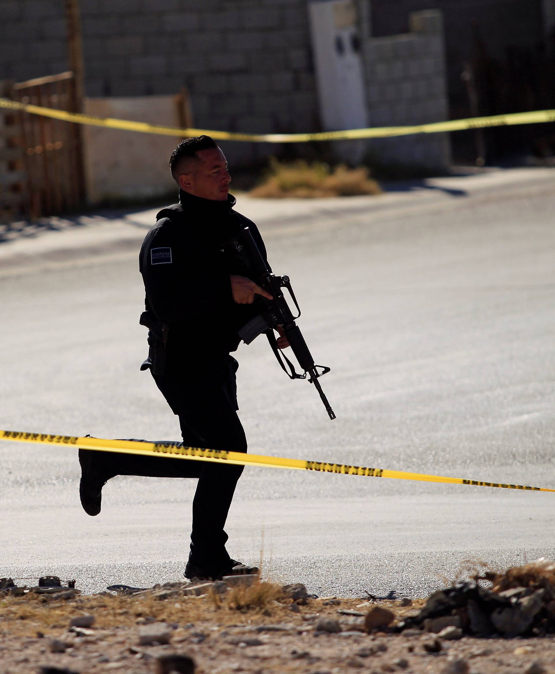 A policeman is seen at a crime scene following an attack on municipal police officers by drug hitmen, according to local media, in Ciudad Juarez