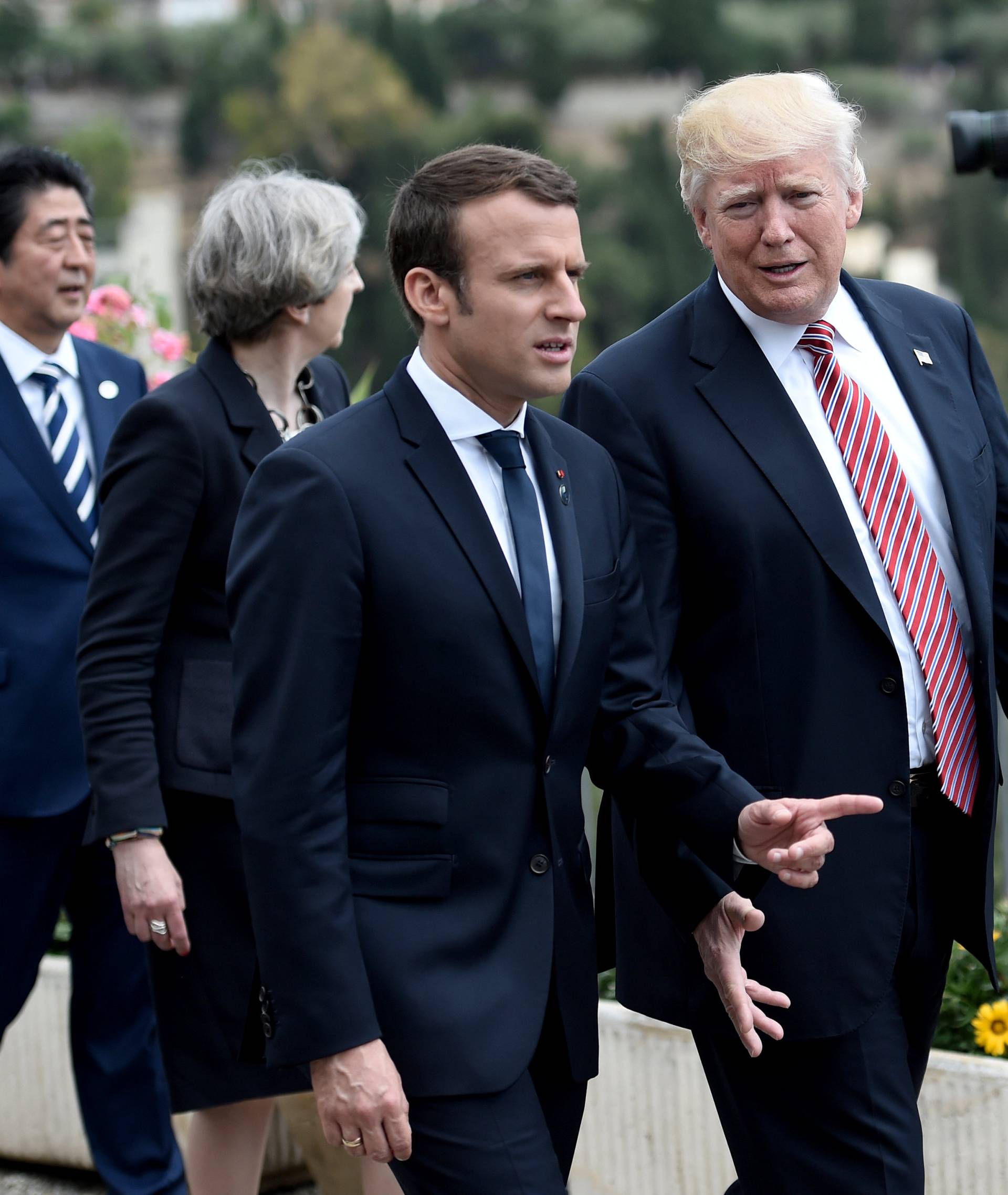 U.S. President Donald Trump talks with French President Emmanuel Macron as they attend the G7 Summit in Taormina, Sicily