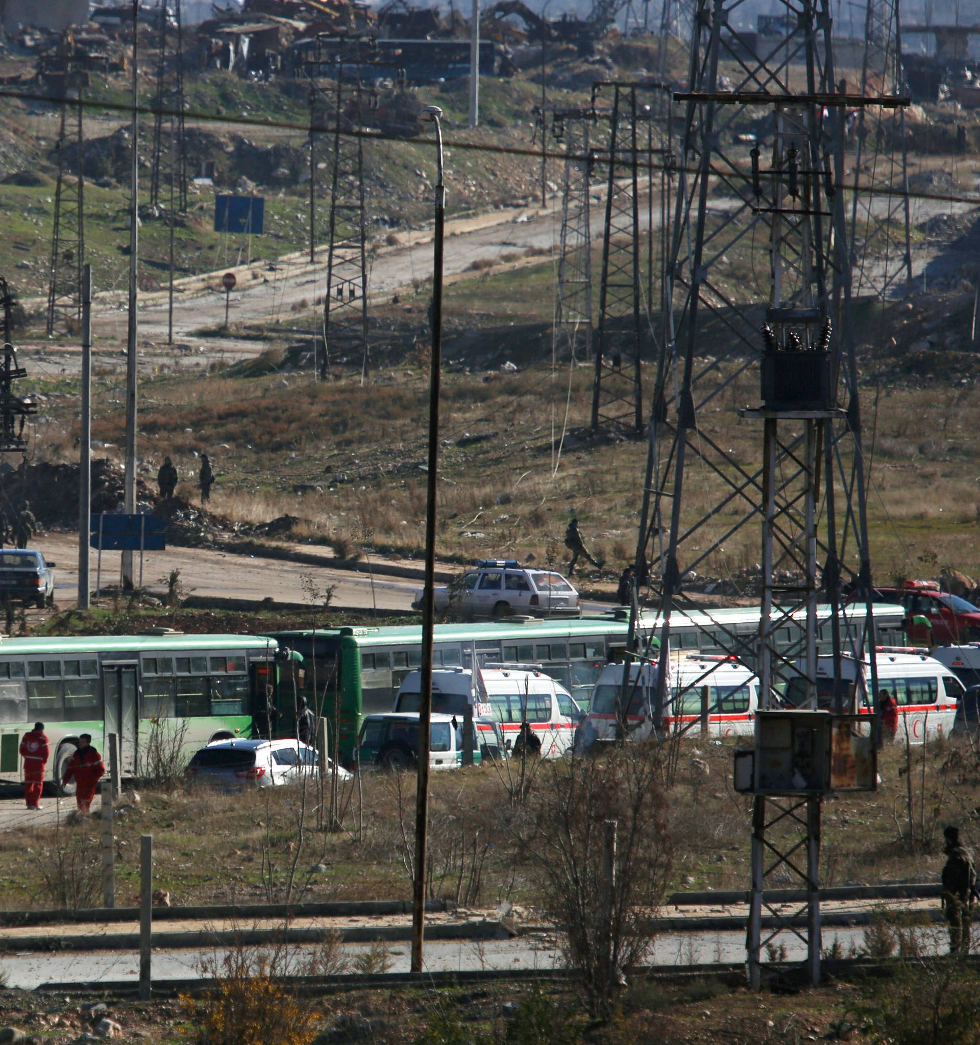 Buses and ambulances wait to evacuate civilians and rebels from eastern Aleppo