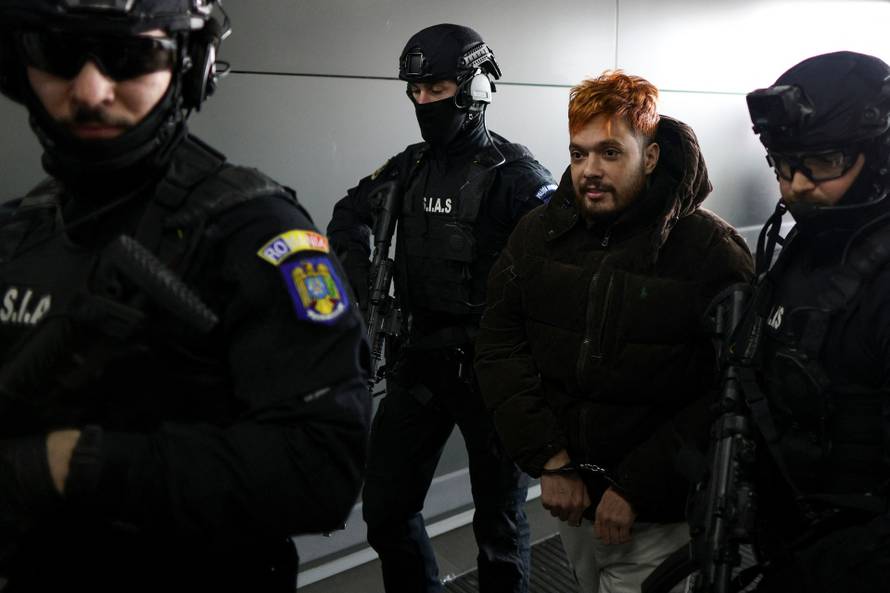 Mohamed Amra is escorted to the tarmac by police officers at Bucharest Henri Coanda International Airport