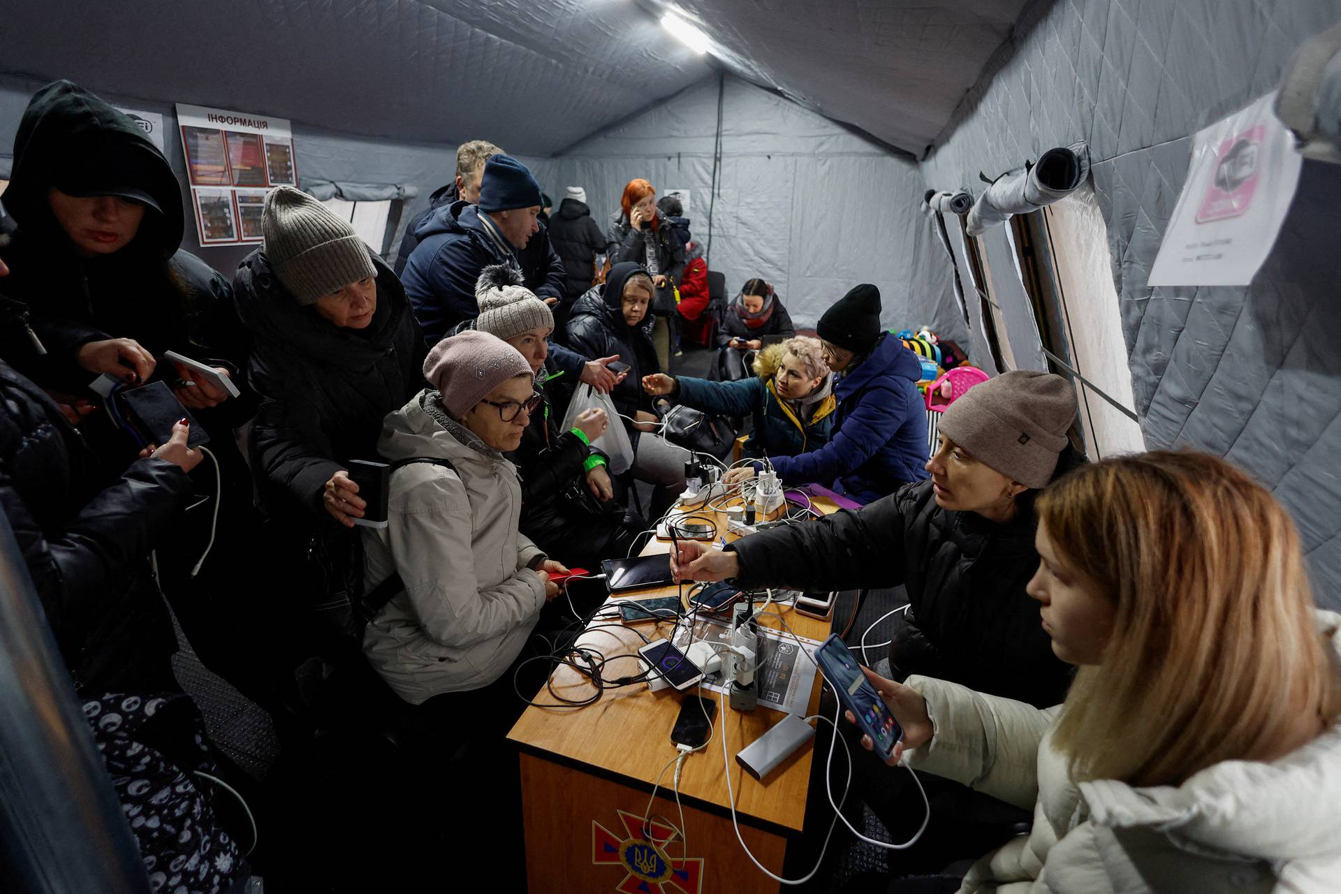 Local residents charge their devices, use internet connection and warm up inside an invincibility centre in Kyiv