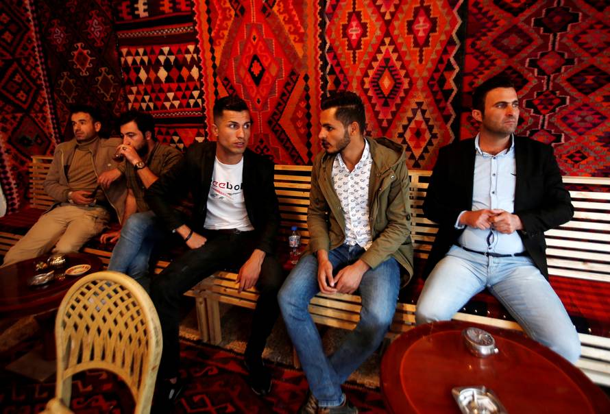 Biwar Abdullah, 25, an Iraqi Kurdish local footballer, who looks like the football player Cristiano Ronaldo, sits with his friends at a cafe in the district of Soran, northeast of Erbil