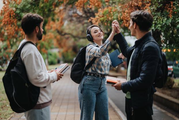 Group of college students celebrating outdoors after exam