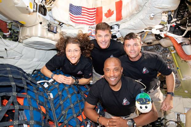 The NASA Artemis II crew pose for a photo