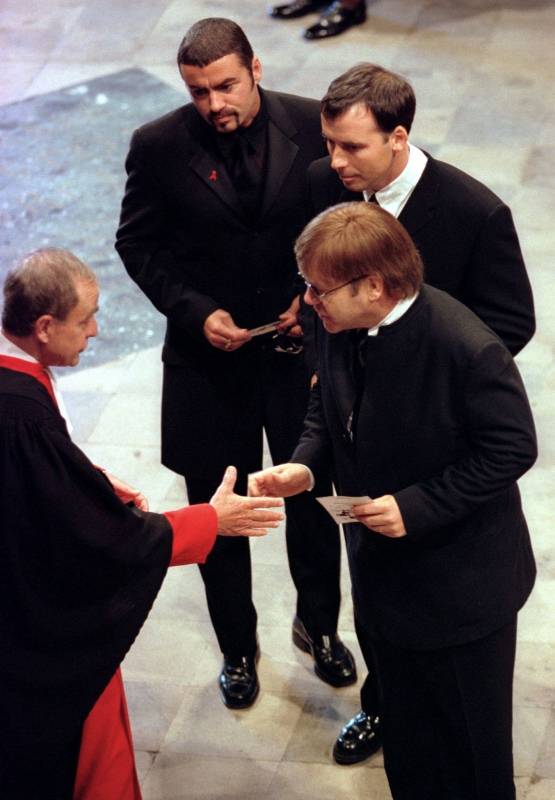 FILE PHOTO: Pop singer George Michael, fellow musician Elton John and his companion David Furnish, are greeted at the funeral service for Diana, Princess of Wales at Westminster Abbey