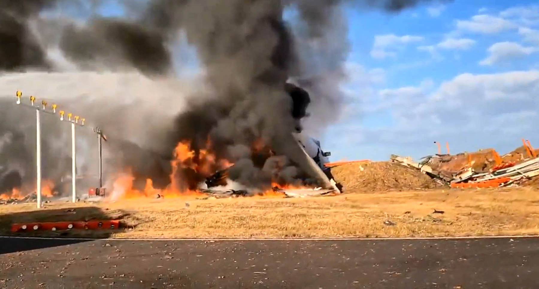 Firefighters carry out extinguishing operations on an aircraft which drove off runaway at Muan International Airport in Muan