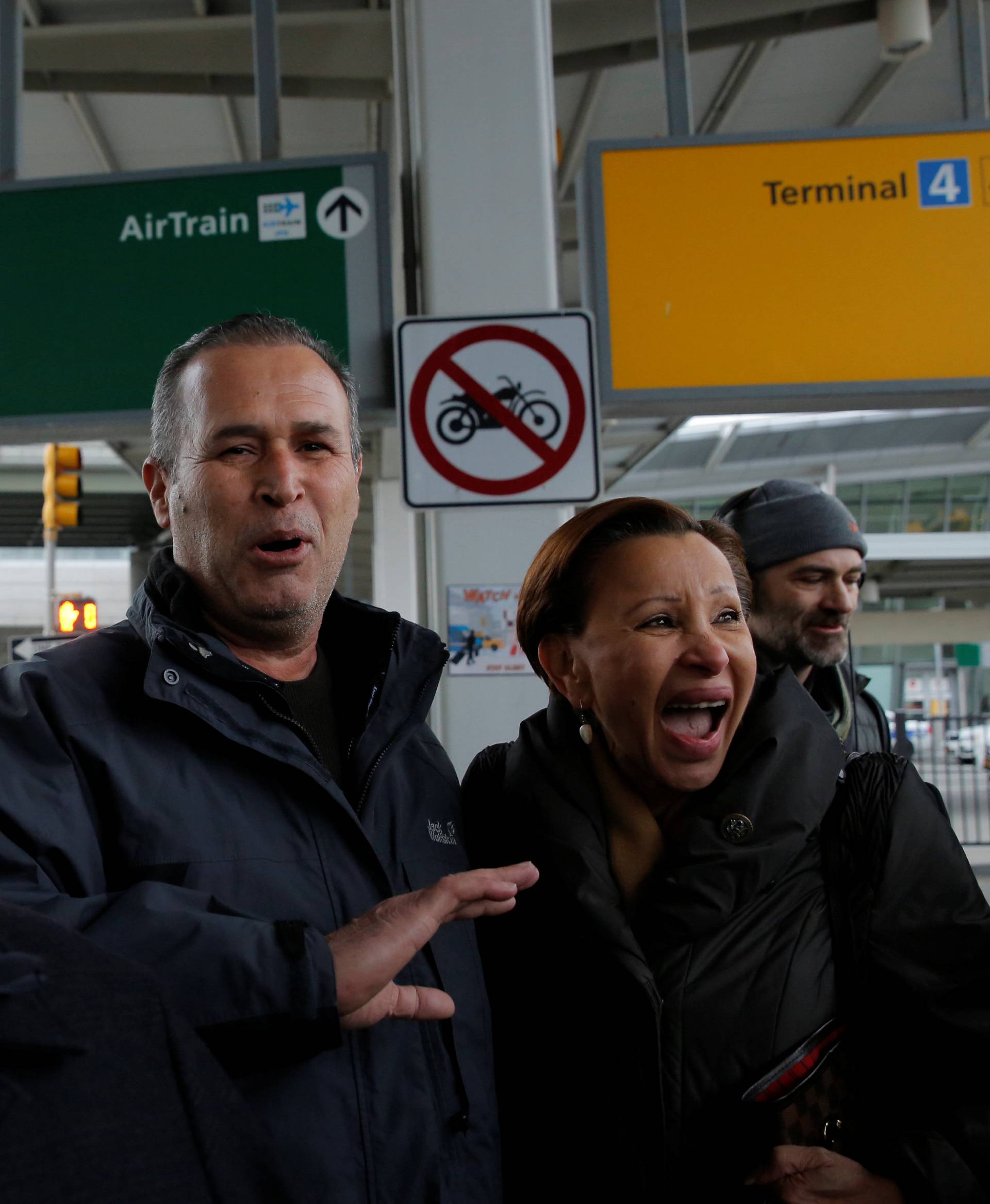 Iraqi immigrant Hameed Darwish (C) walks out of Terminal 4 with Congressman Jerrold Nadler (L) and Congresswoman Nydia Velazquez (R) after being released at John F. Kennedy International Airport in Queens, New York, U.S.