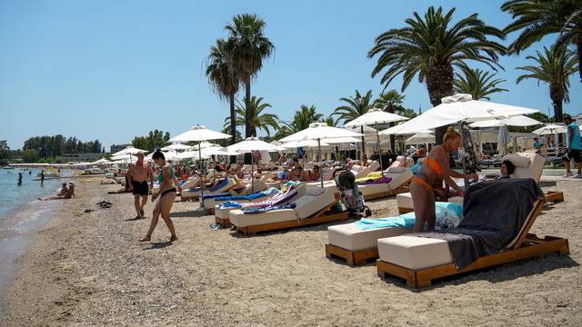 FILE PHOTO: People visit Dassia beach on the island of Corfu