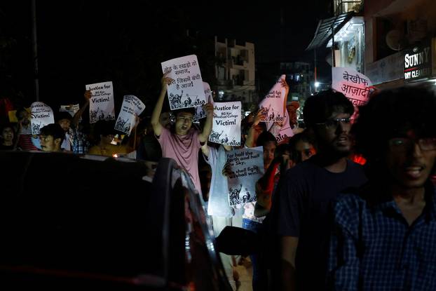 Students shout slogans as they hold placards during a protest rally demanding justice