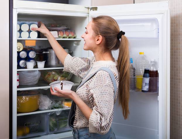 Happy,Young,Longhaired,Woman,Arranging,Products,On,Fridge,Shelves,And