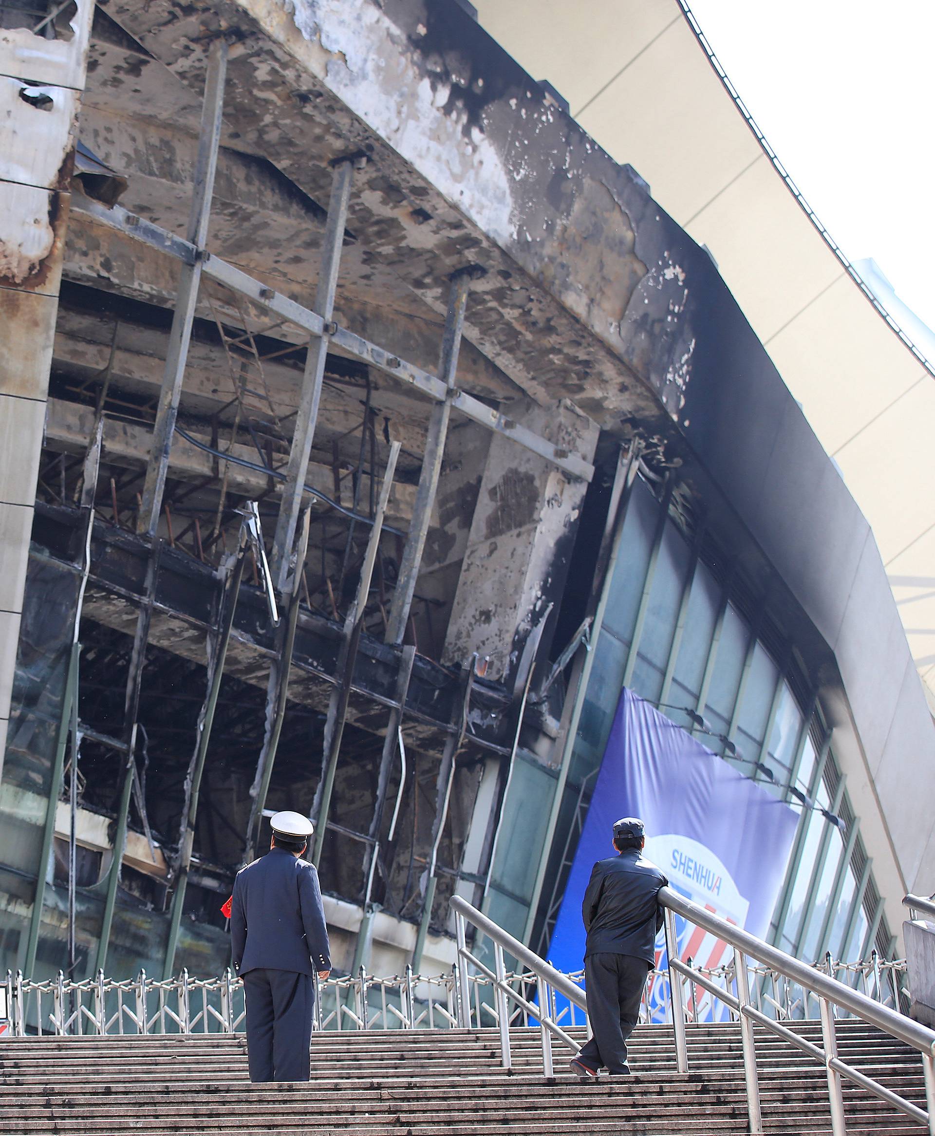 Rescue workers stand outside the site where a fire broke out at the Shanghai Hongkou soccer stadium in Shanghai