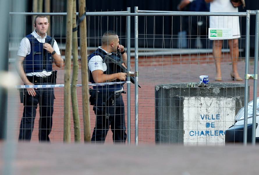 Belgian police officers stand guard outside the main police station after a machete-wielding man injured two female police officers before being shot in Charleroi