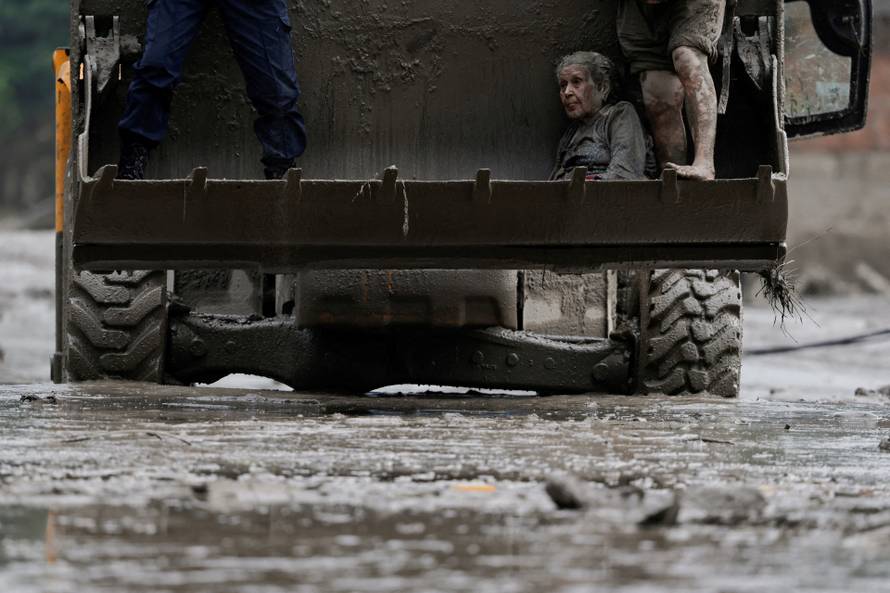 A survivor is transported to a safer place in heavy machinery following a flash flood at Trishuli, Nepal
