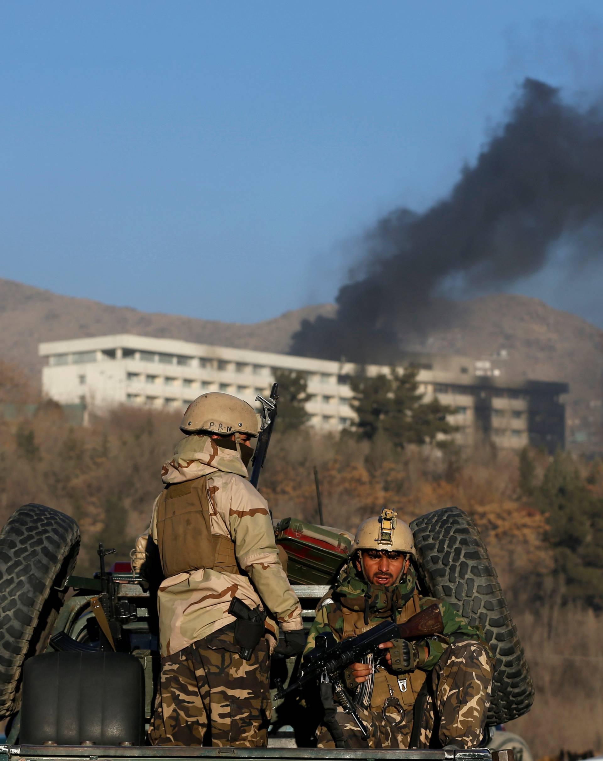 Afghan security forces keep watch as smoke rises from the Intercontinental Hotel in Kabul,ÃAfghanistan