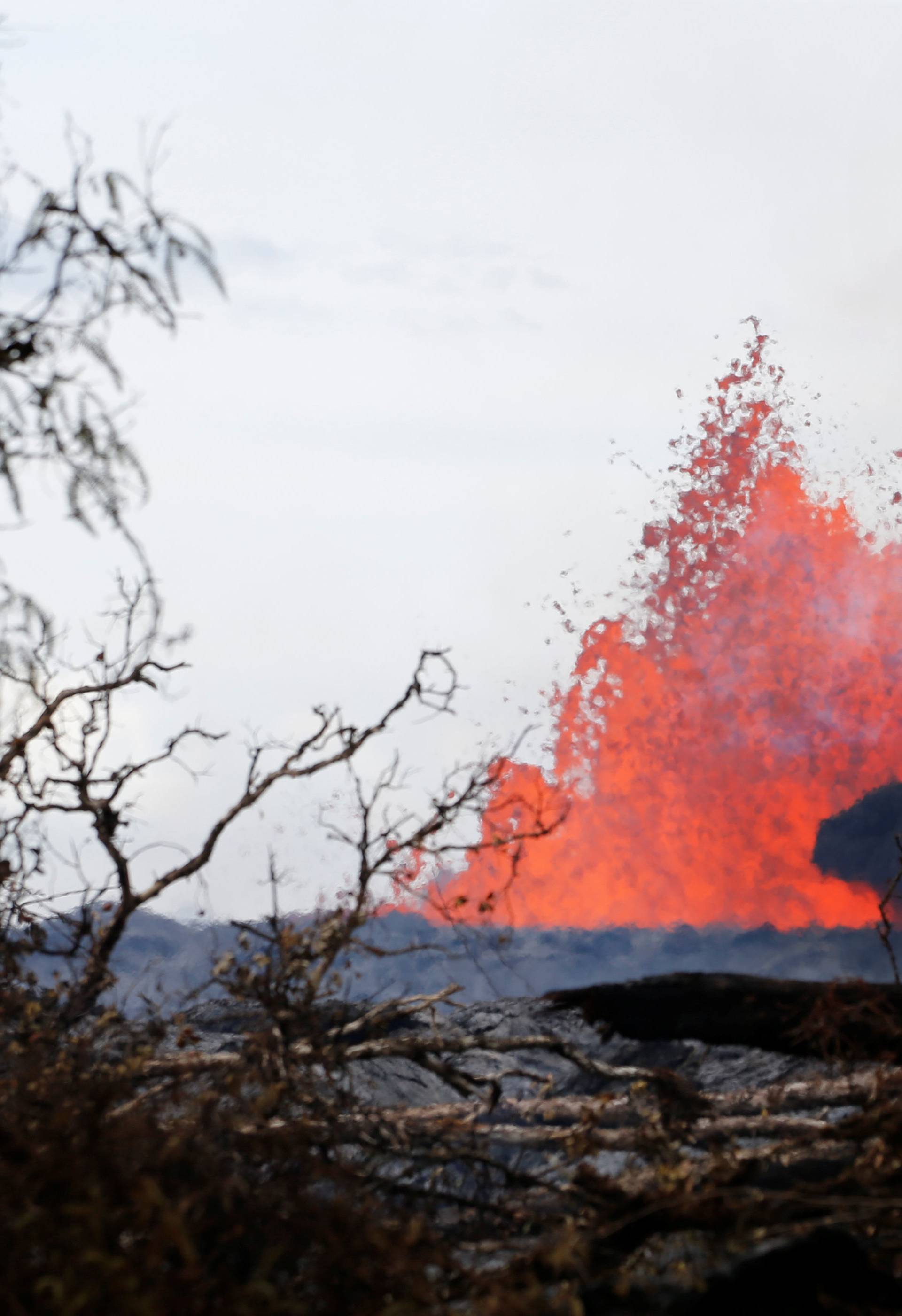 A volcanic fissure spurts molten rock into the air near Nohea Street, in the Leilani Estates, near Pahoa, Hawaii