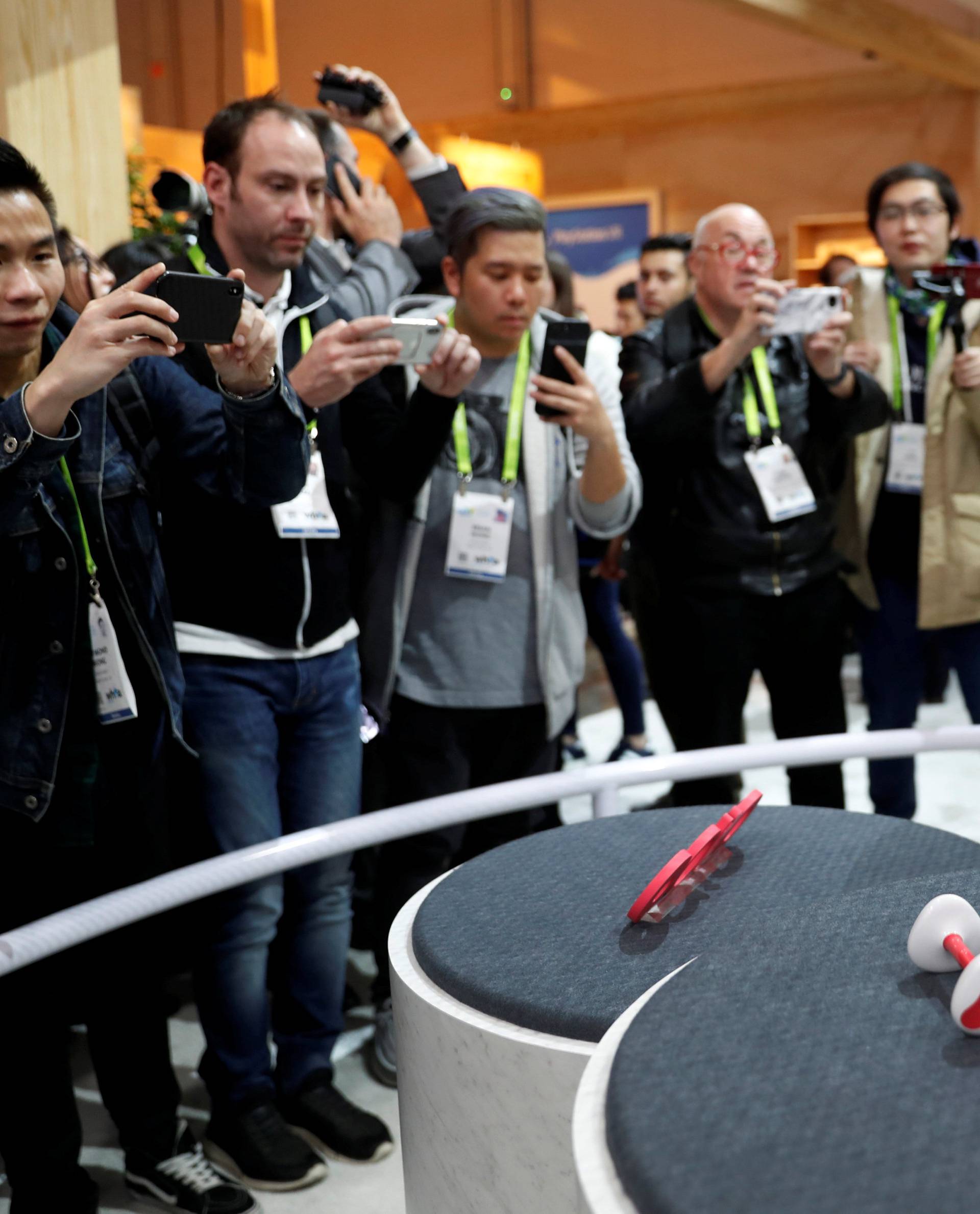 Journalists take photos of Aibo, a robotic dog, during a Sony news conference at the 2018 CES in Las Vegas