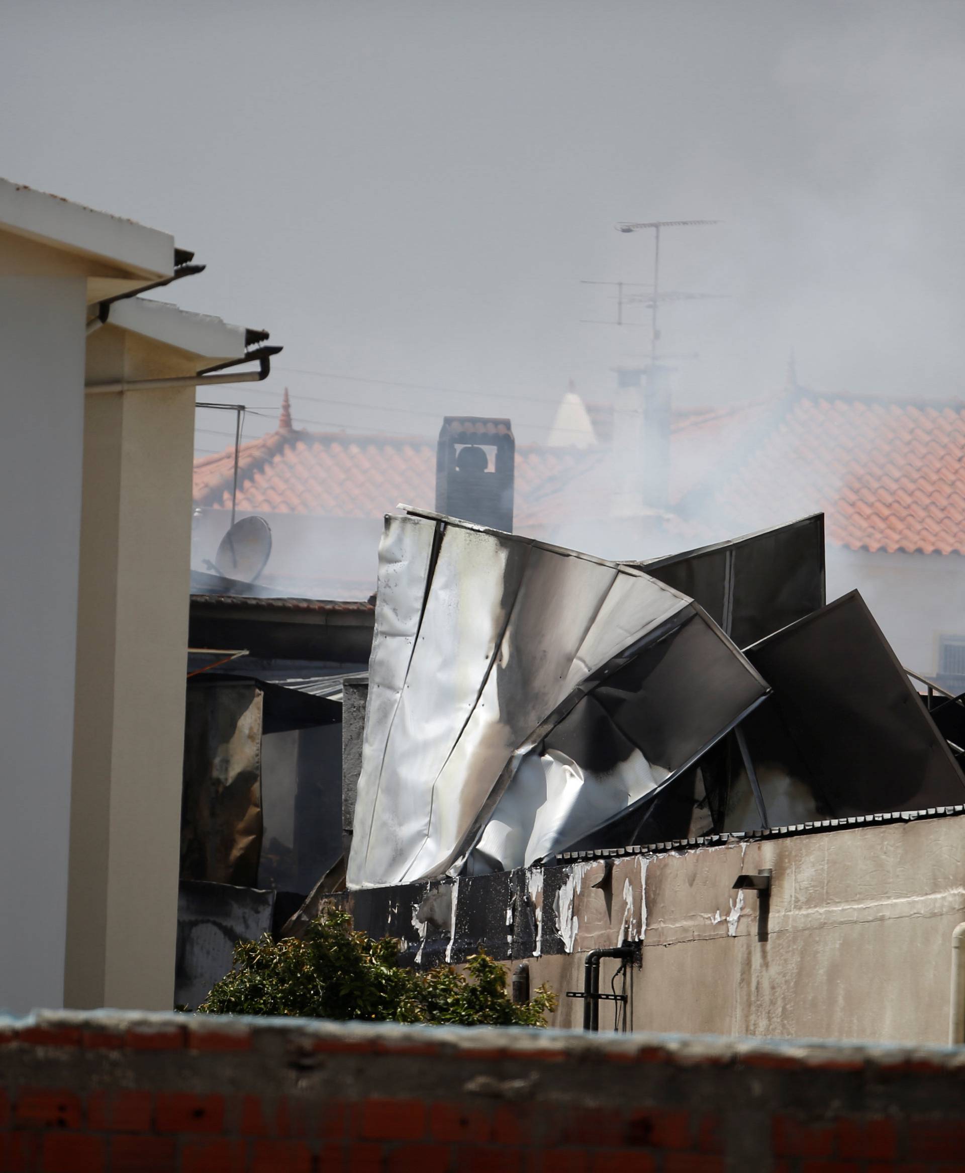 Smoke is seen where a small airplane crashed near a supermarket in a residential area outside Lisbon, Portugal