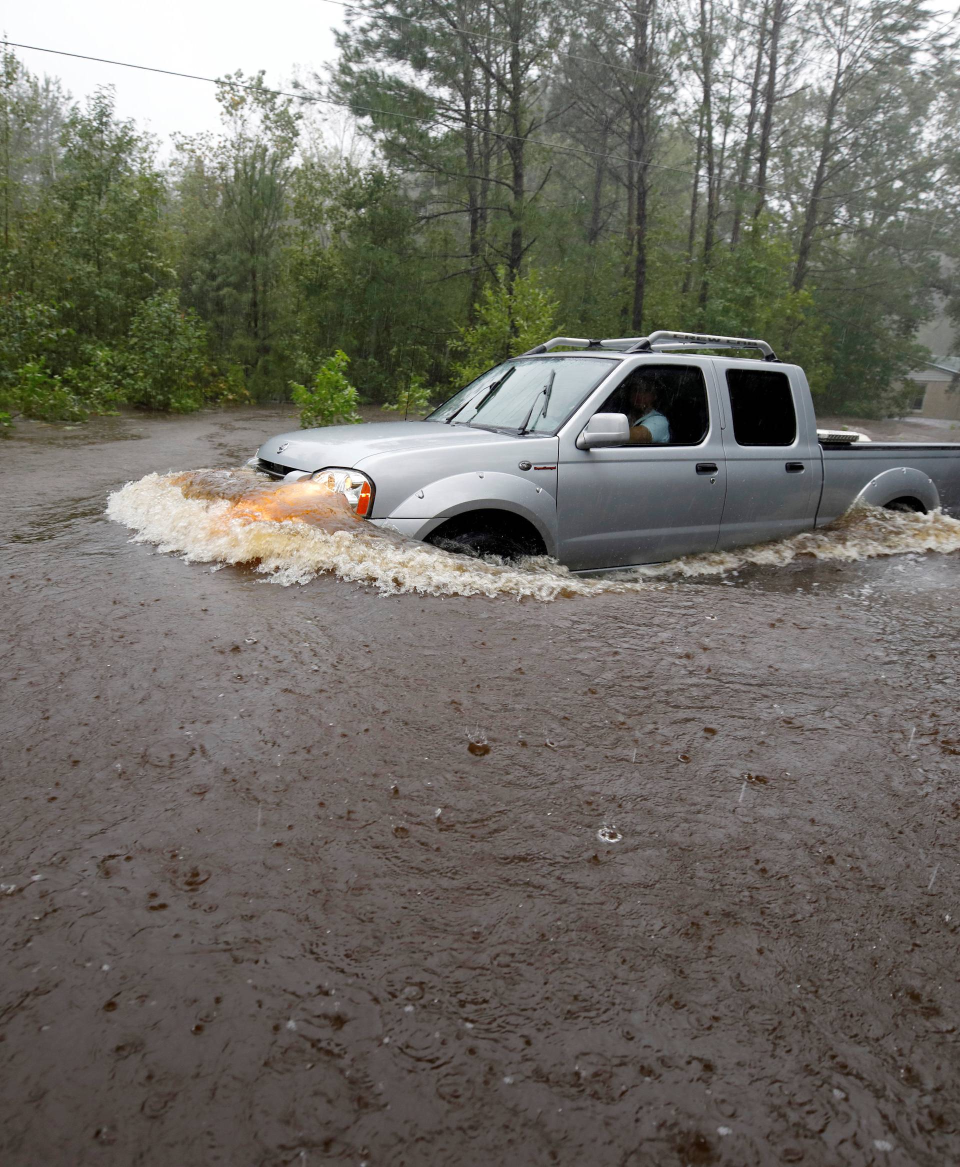 A motorist drives through high waters after Hurricane Florence swept through in North Carolina