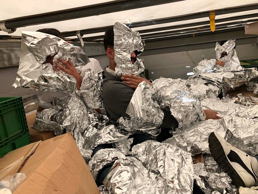 3 of the 7 Iraqi refugees wraped in aluminium foil to hide from an x-ray detector are pictured inside a truck at Pendik Port as they try to reach Italy in Istanbul