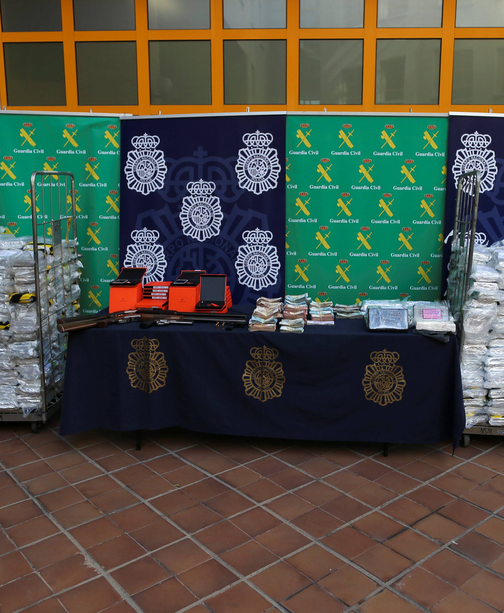 Police display a portion of the six tonnes of cocaine, money and other material seized at an industrial estate at the police headquarters in Malaga