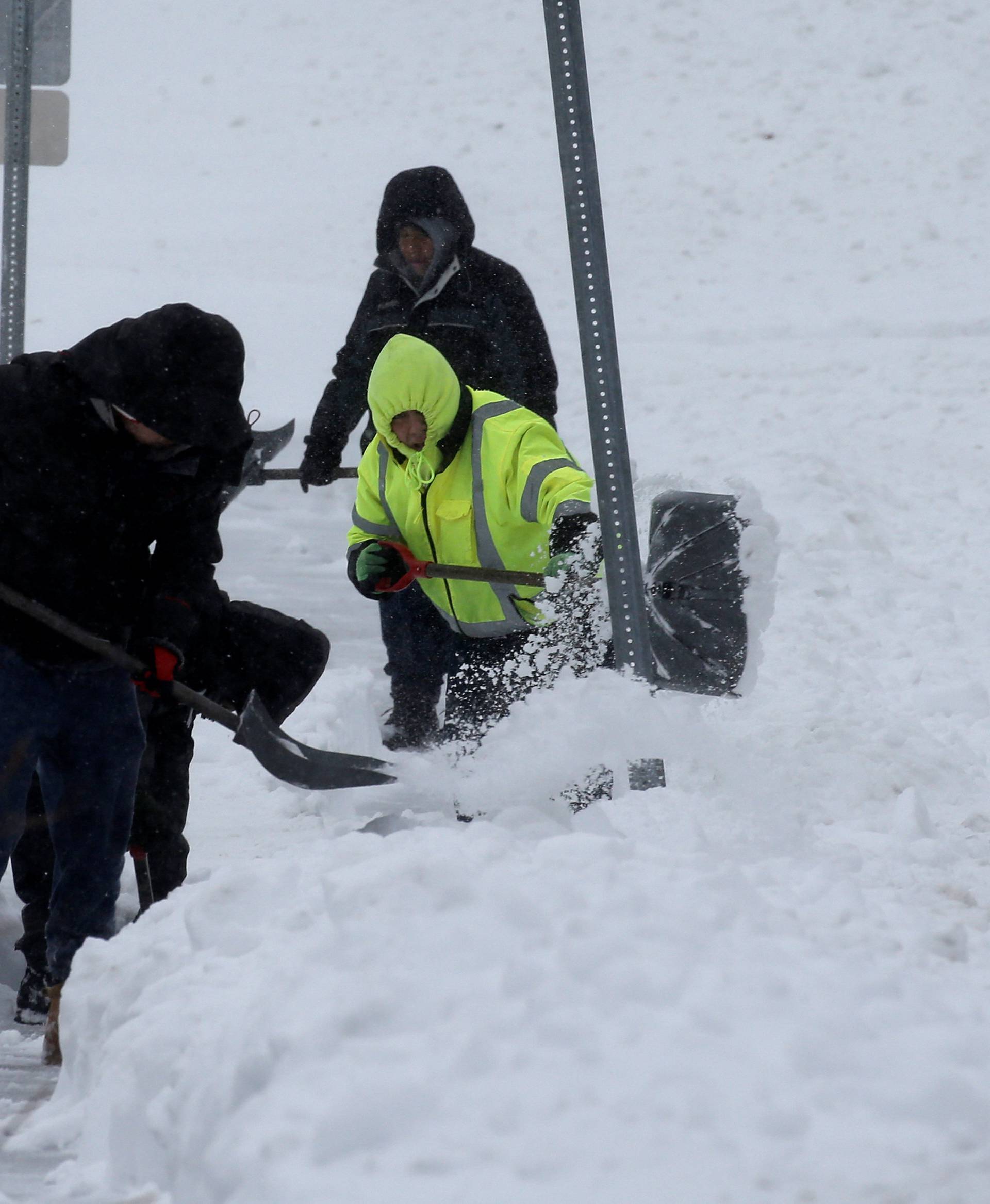 Men shovel snow during a snowstorm in the village of Nyack