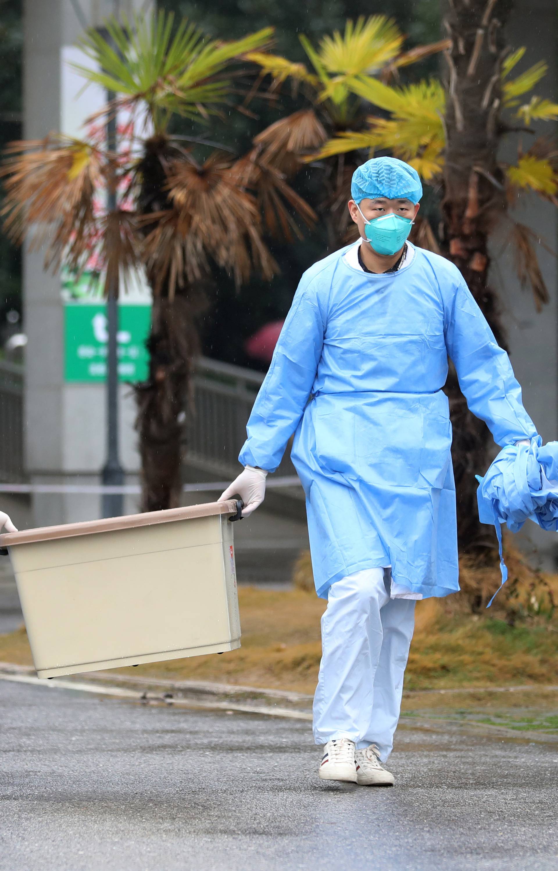 Medical staff carry a box as they walk at the Jinyintan hospital, where the patients with pneumonia caused by the new strain of coronavirus are being treated, in Wuhan