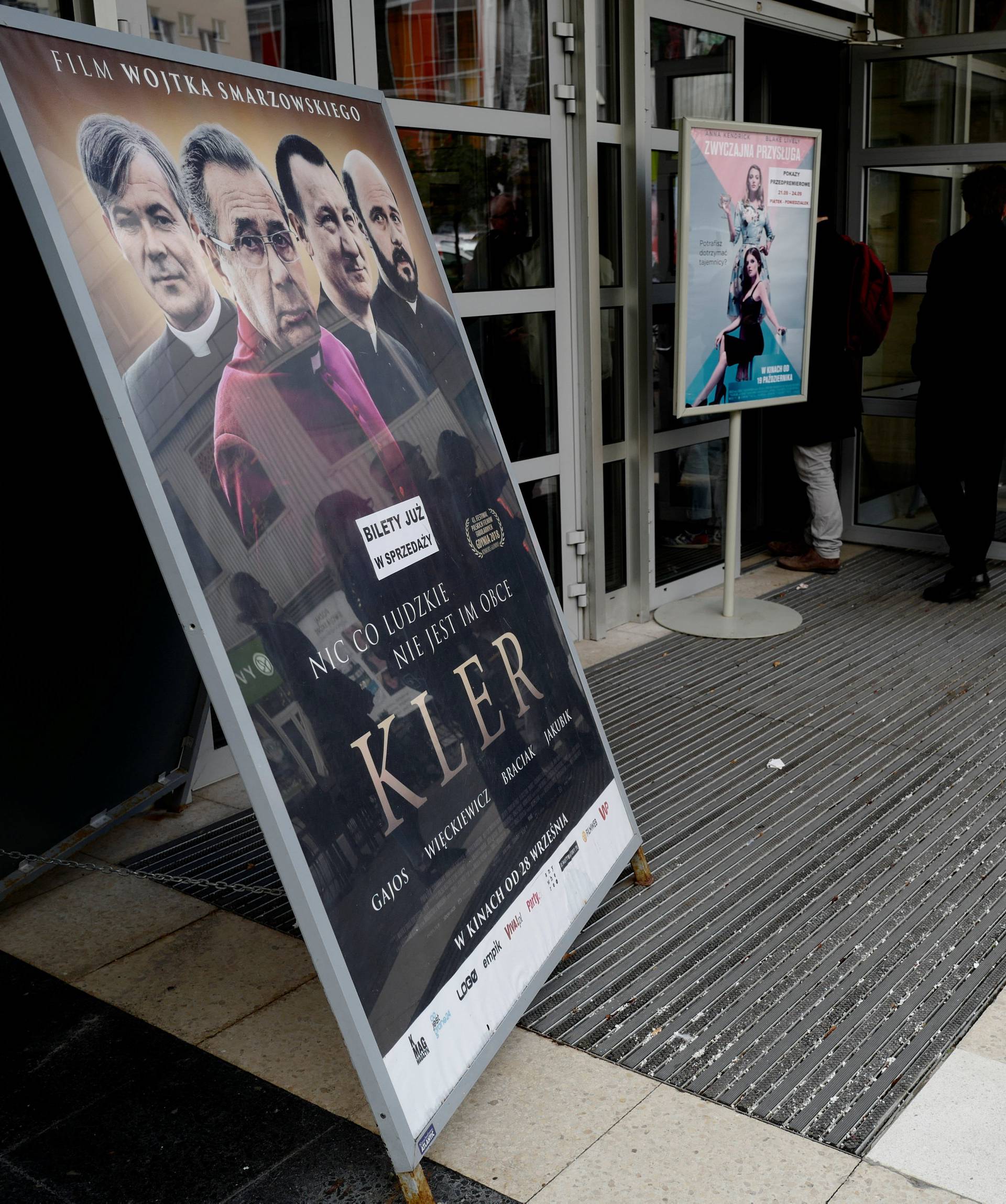 People stay in line outside a cinema before the screening for the press of the Polish movie "Kler" directed by Wojciech Smarzowski in Warsaw