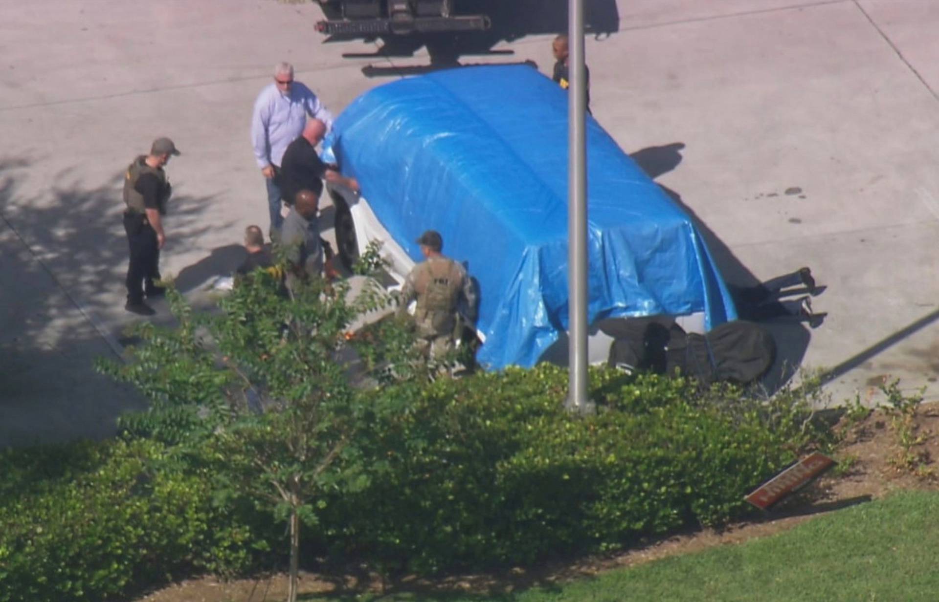 Law enforcement officers stand near a van which was seized during an investigation into a series of parcel bombs, in Plantation