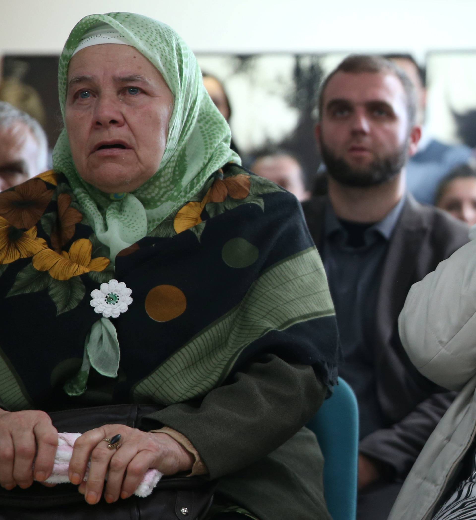 A woman reacts as she watches a television broadcast of the court proceedings of former Bosnian Serb general Ratko Mladic in the Memorial centre Potocari near Srebrenica