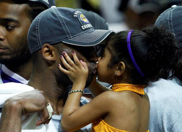 FILE PHOTO: Los Angeles Lakers Kobe Bryant kisses his daughter Gianna after they defeated the Orlando Magic to win the NBA basketball championship in Orlando