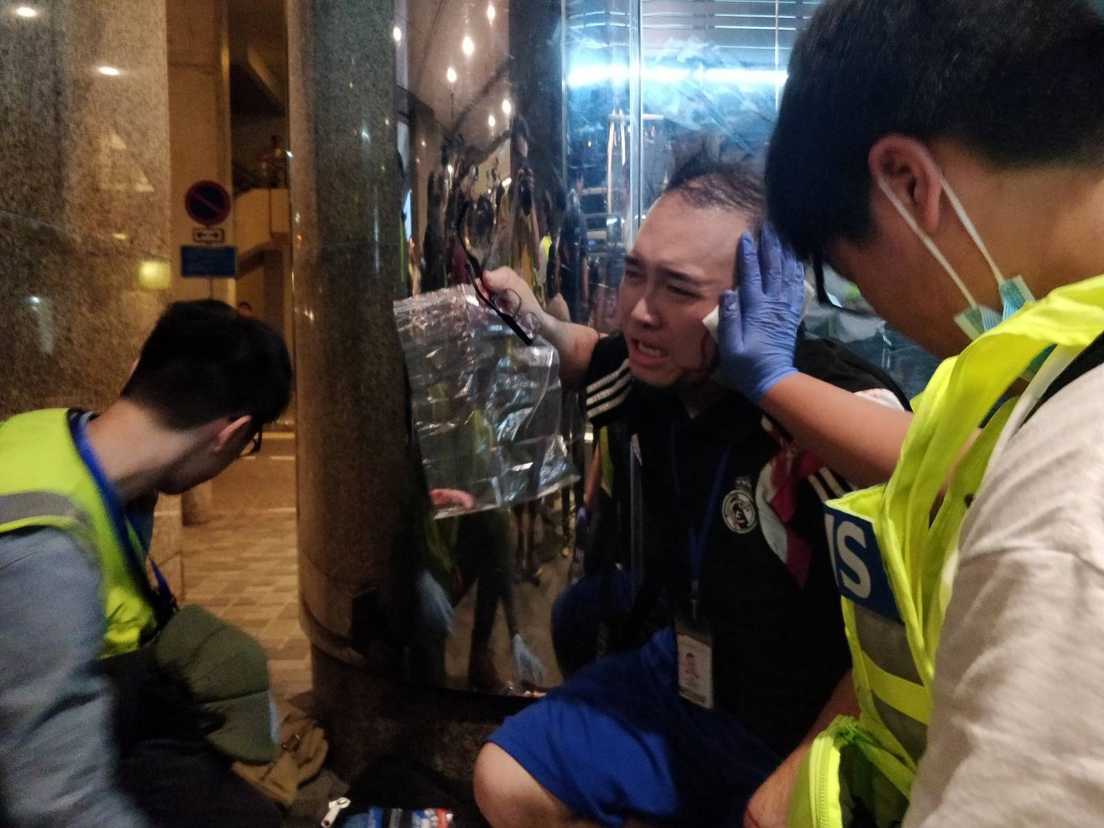 Andrew Chiu Ka Yin, District Councillor of Taikoo Shing West, receives help from first aid volunteers after sustaining an injury in a knife attack at a shopping mall, in Taikoo Shing in Hong Kong