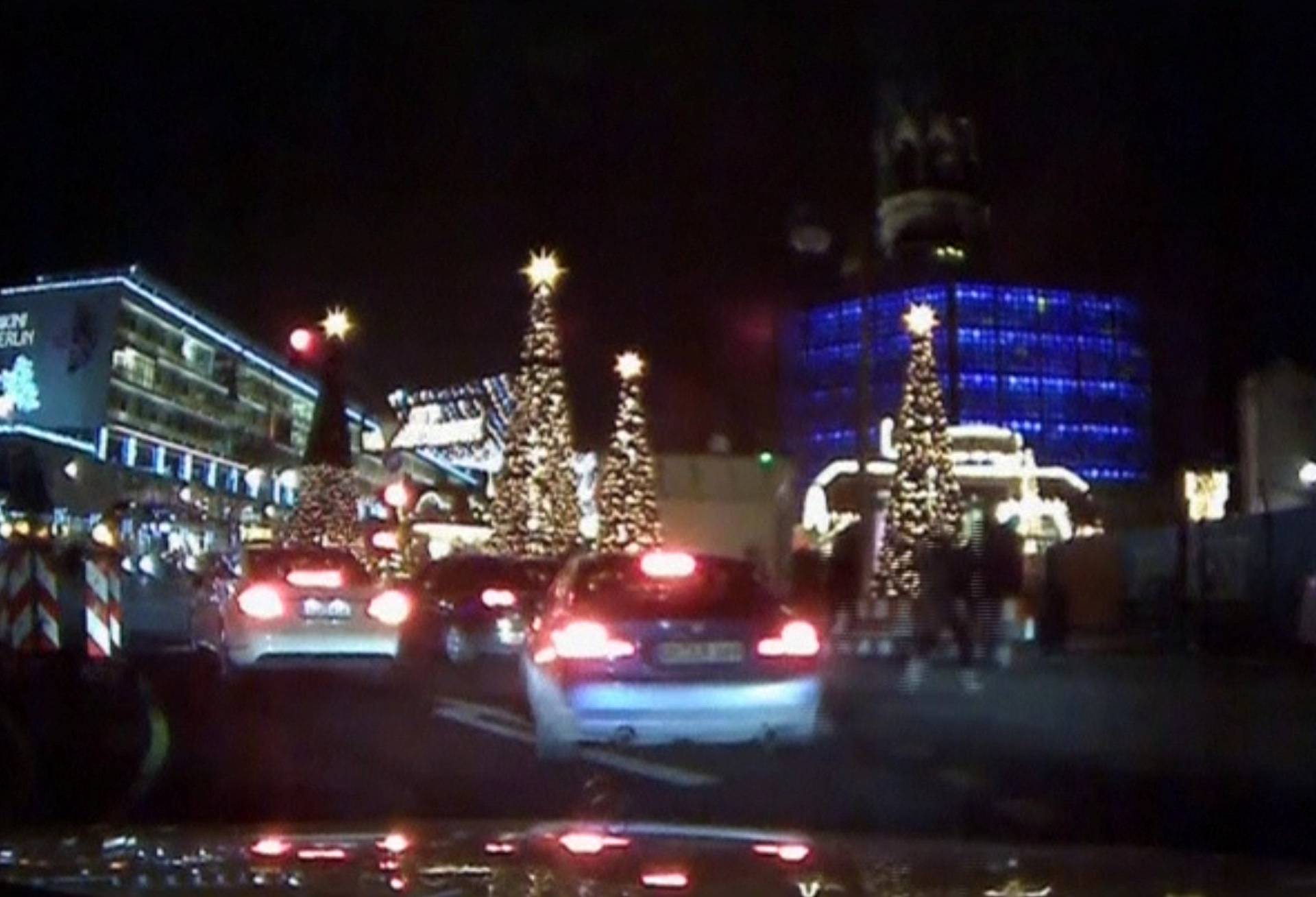 An image grab from a car dash camera shows people running away after a truck plowed into a Christmas market in Berlin