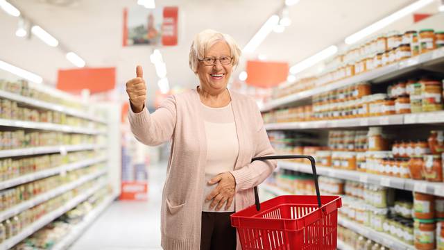 Elderly woman with a shopping basket in a supermarket 