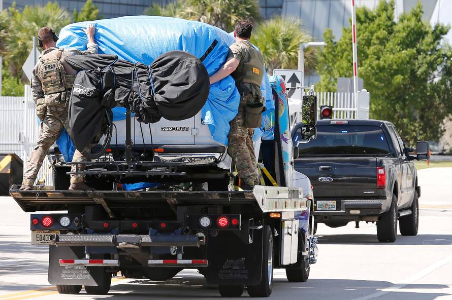 A white van is towed into FBI headquarters in Miramar