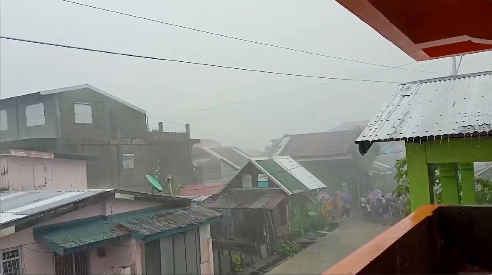 People walk as Typhoon Kammuri, known locally as Typhoon Tisoy, makes landfall in Gamay
