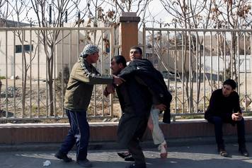 Injured man is carried after a blast in Kabul