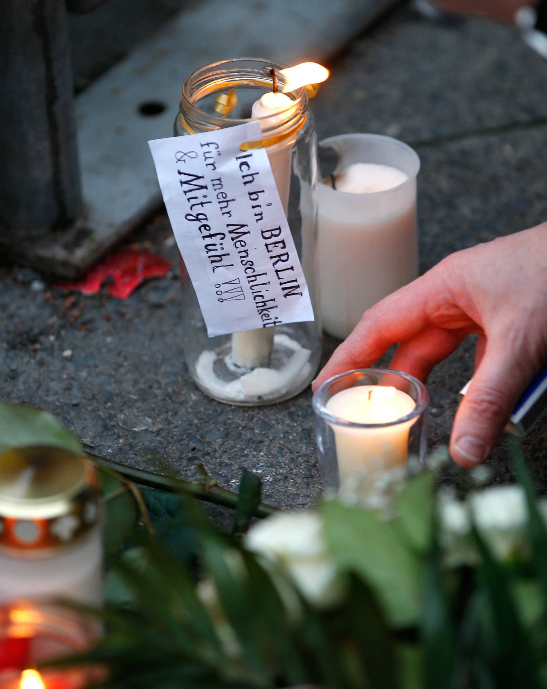 A candle with a sticker reading "I am Berlin - For more humanity and compassion" near the scene where a truck ploughed into a crowded Christmas market in the German capital last night in Berlin