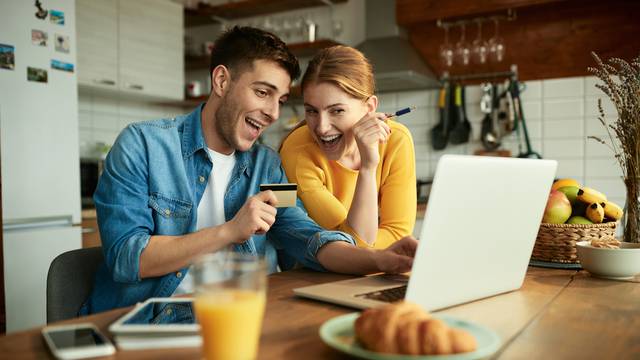 Young,Happy,Couple,Using,Laptop,And,Credit,Card,While,Shopping
